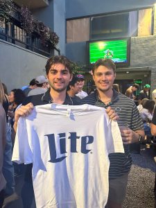 Two young men holding a Miller Lite shirt